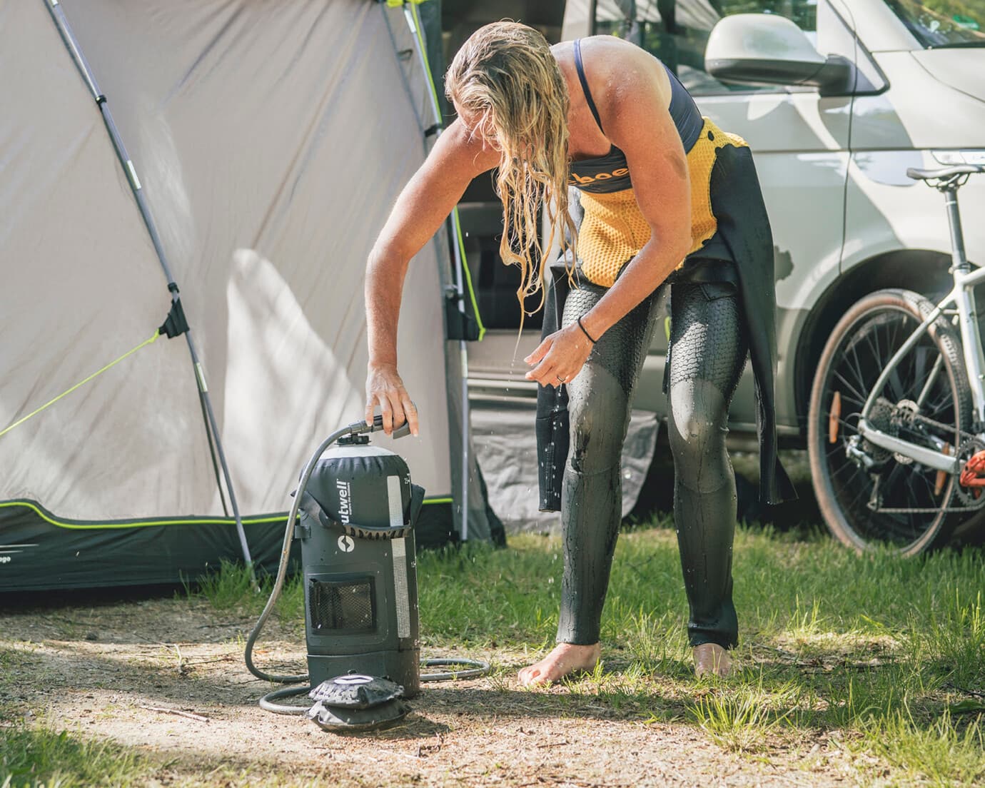 Outwell Seabreeze Pressure Shower in use with woman in wetsuit