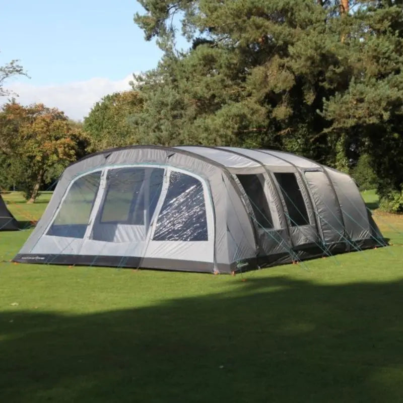 Outdoor Revolution Camp Star 700 inflatable tent on grass with trees in the background.