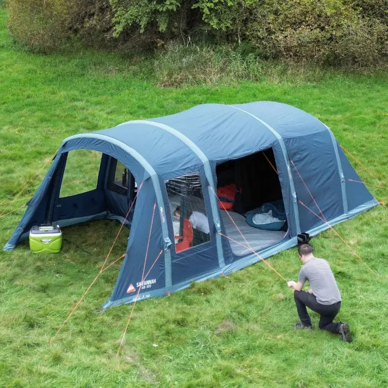 Vango AirBeam Savannah Air 400 tent set up on grass with a person inside and another outside.