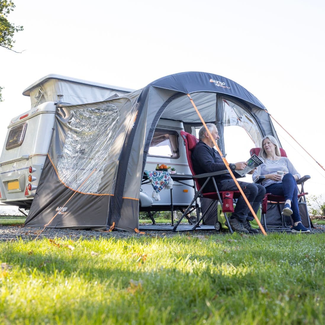 Vango Sunlight Air sun canopy connected to a camper van, offering a shaded area for relaxation.