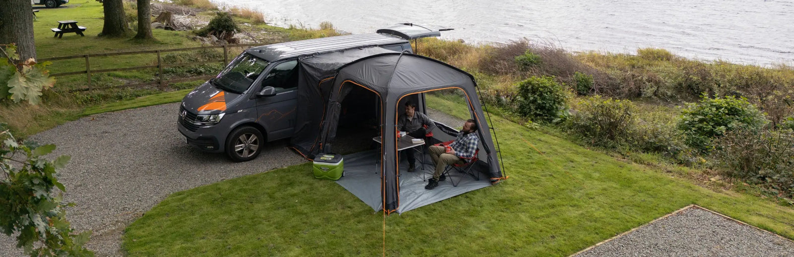 Vango Tailgate Hub II Tailgate awning pitched by a river.