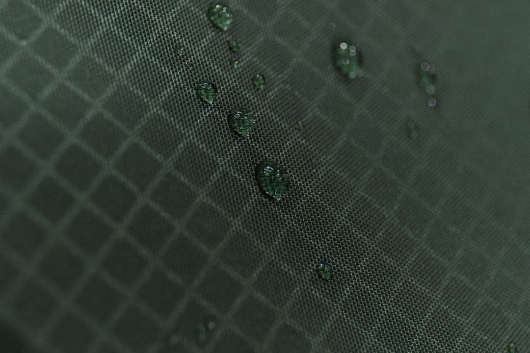 Close-up view of tent fabric with water droplets highlighting hydrostatic head ratings, waterproof levels for tents, and awning hydrostatic head guide.