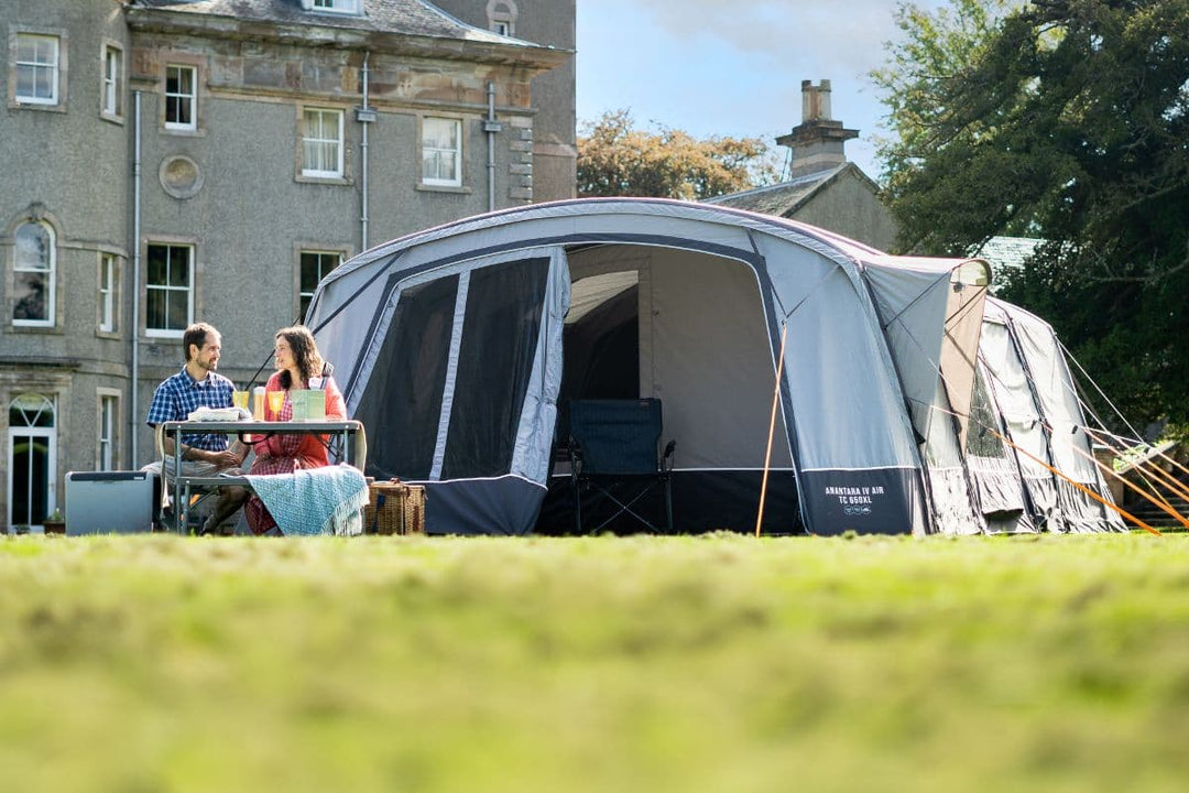Couple enjoying a picnic outside a large camping tent, illustrating the use of durable and waterproof Tent Fabrics, breathable Camping Tent Materials, and versatile Tent Fabric Types for various camping needs.