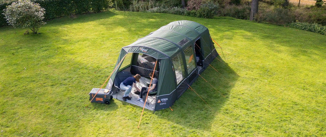 4 man air tent set up on a summer campsite.
