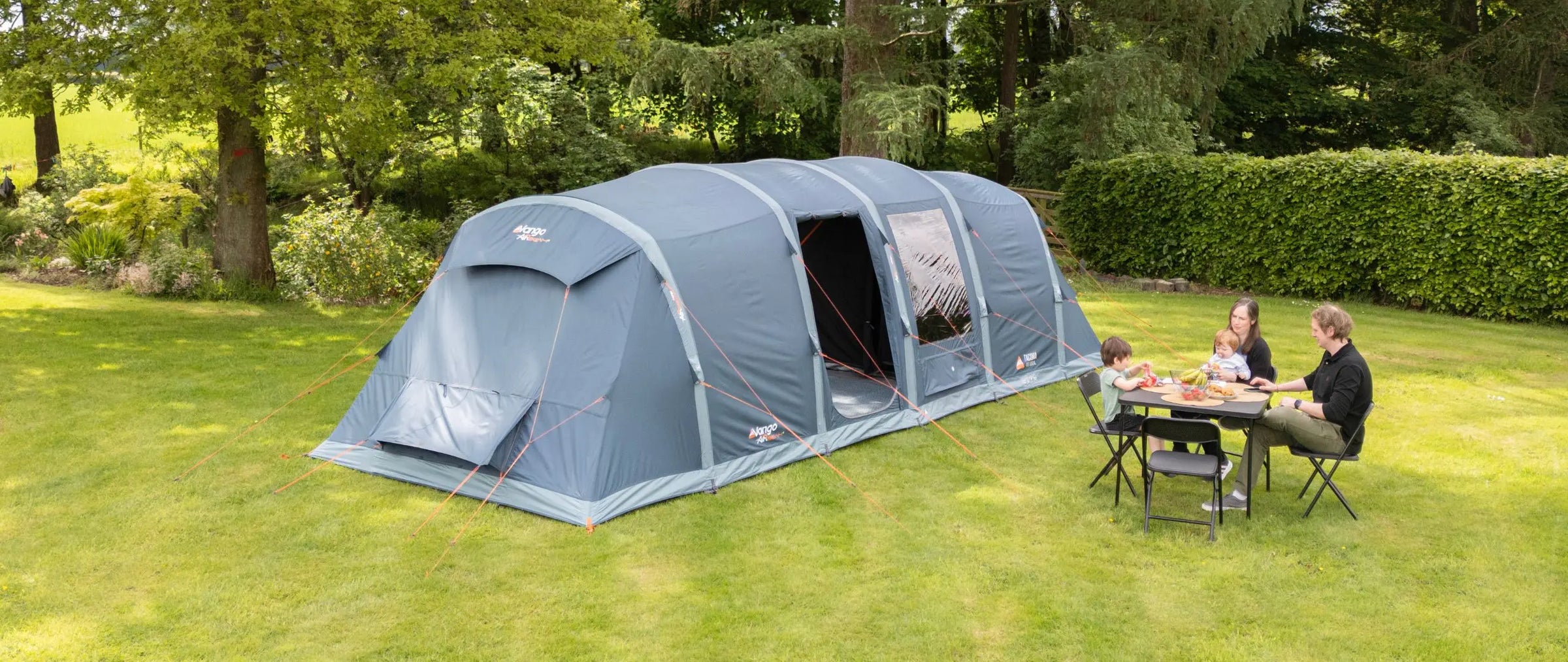 Large air tents with a family camping outside.