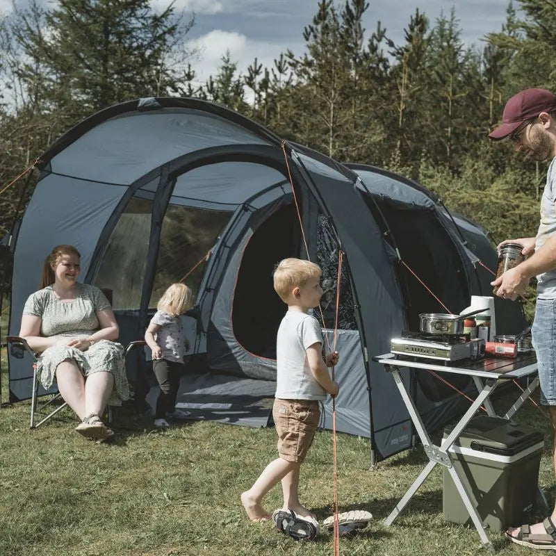 Family camping outdoors with a Skarvan 4 man tent and cooking equipment.
