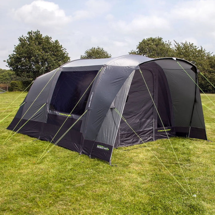 Side view of the Outdoor Revolution Airedale 400T Air Tent on grass with trees in the background