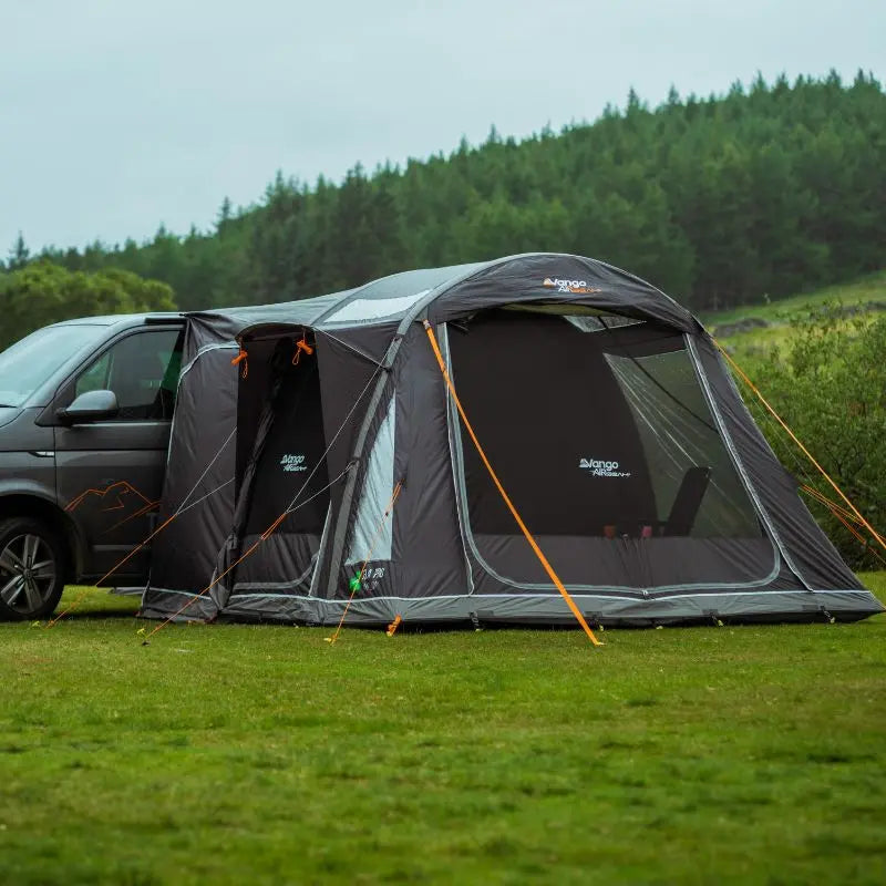 Vango Kela Pro Low campervan awning connected to a VW Camper in a grassy outdoor setting