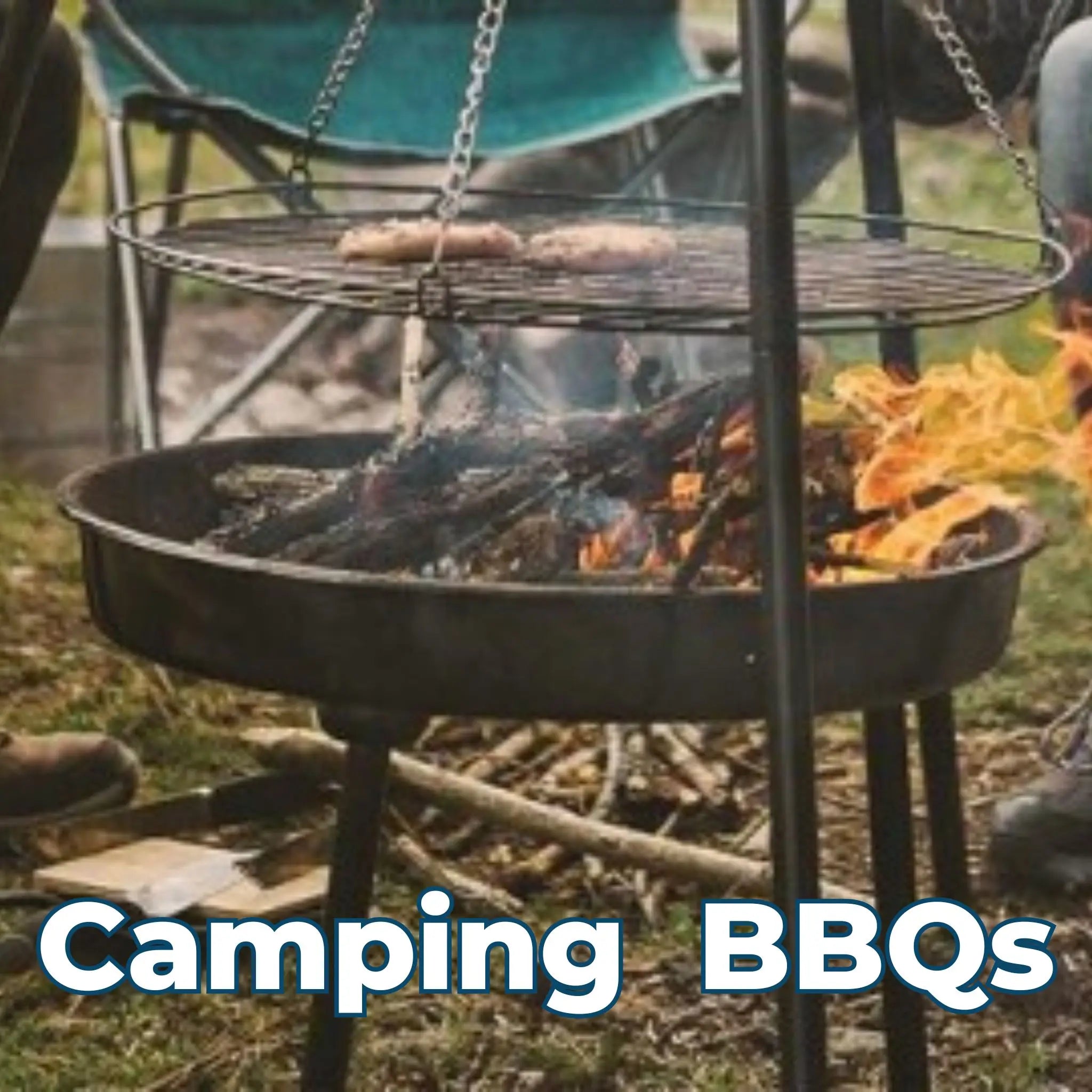 Portable camping BBQ with sausages grilling over an open fire, surrounded by outdoor chairs.