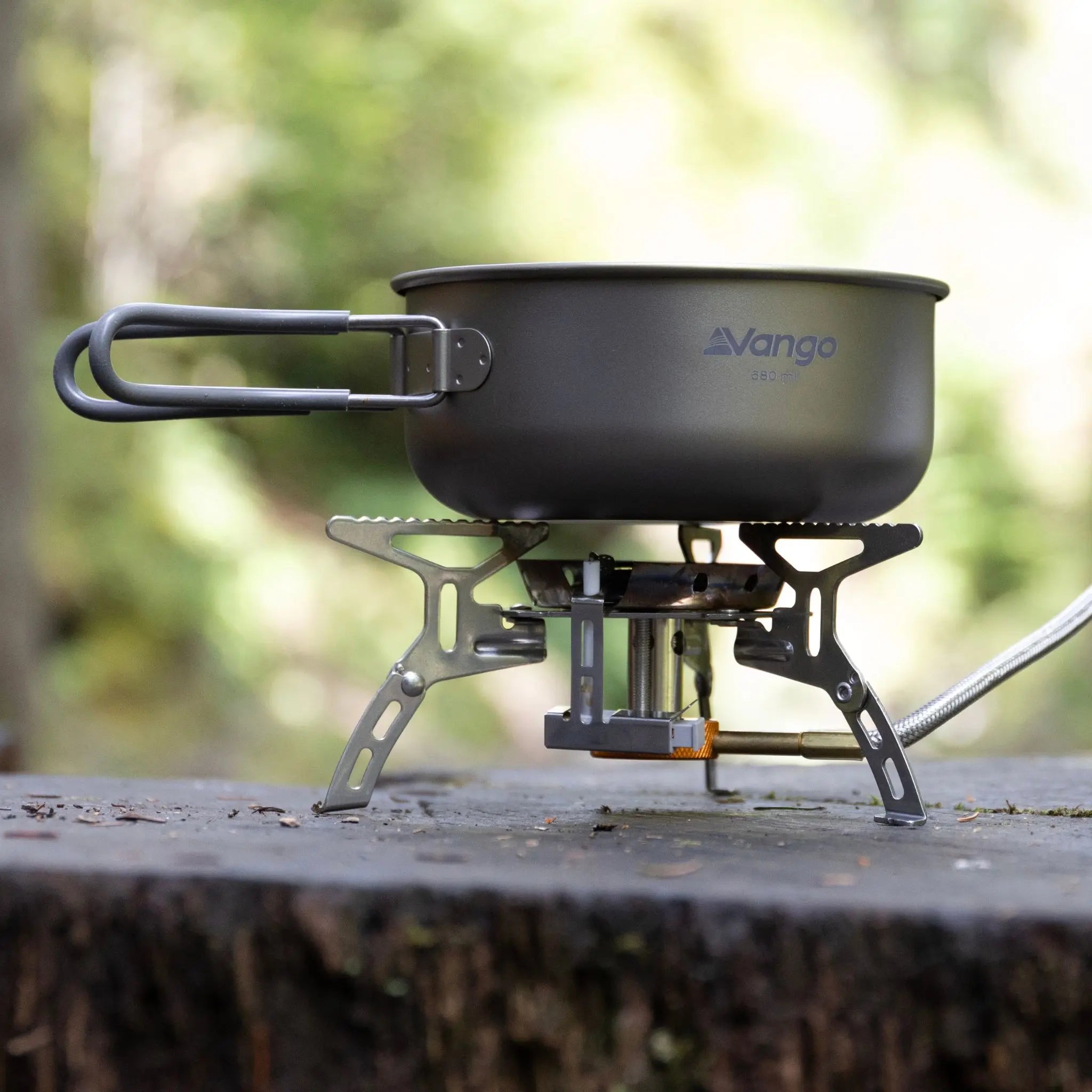 Vango camping pan set placed on a portable camping stove, ideal for outdoor cooking during camping trips.