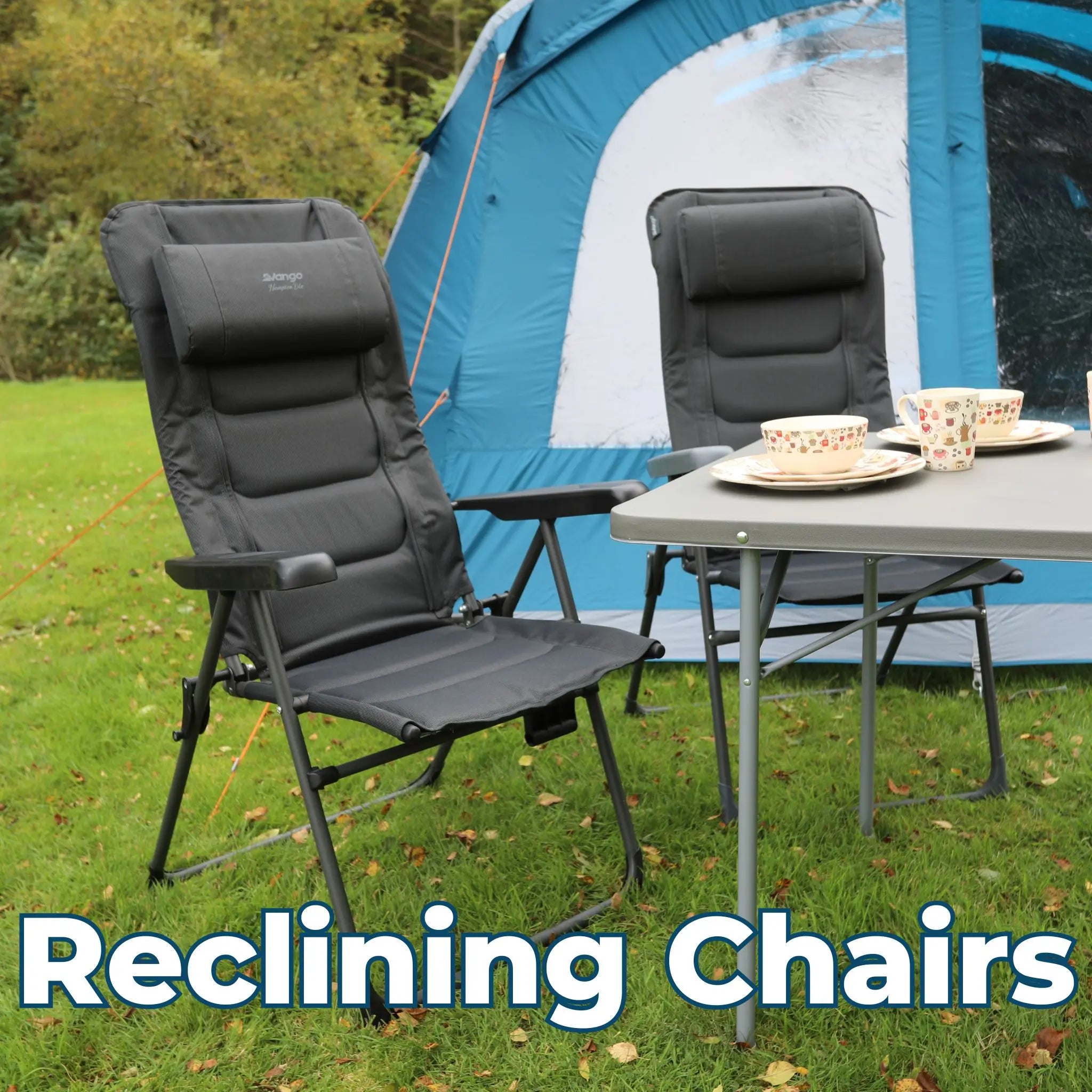 Two black Vango reclining chairs set up at a camping table, placed outdoors near a tent for a relaxing outdoor dining experience.