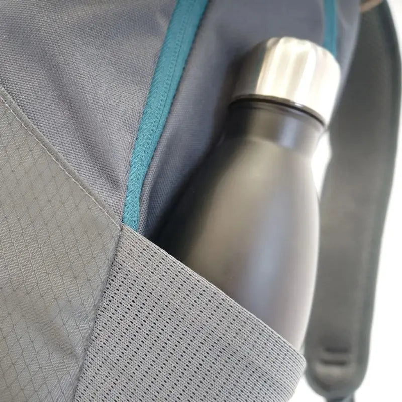 Silver water bottle in a gray day pack with teal zipper