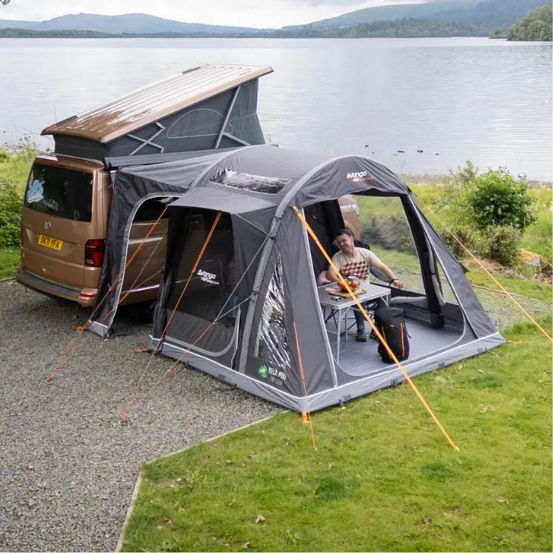 VW Campervan with a pop-up roof and attached drive away awning by a lake