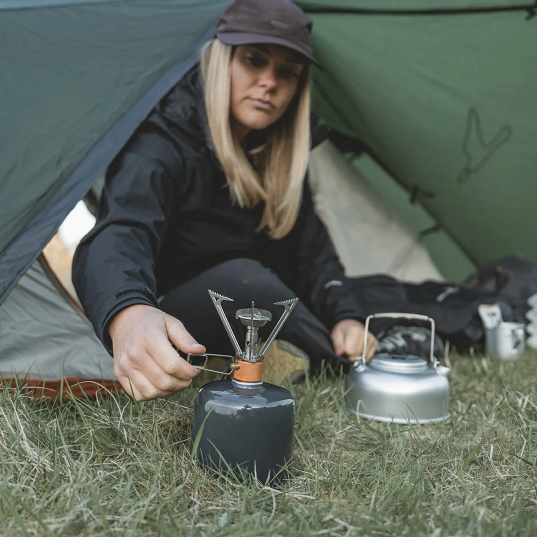 Easy Camp Adventure Burner lifestyle image with it being used next to a tent