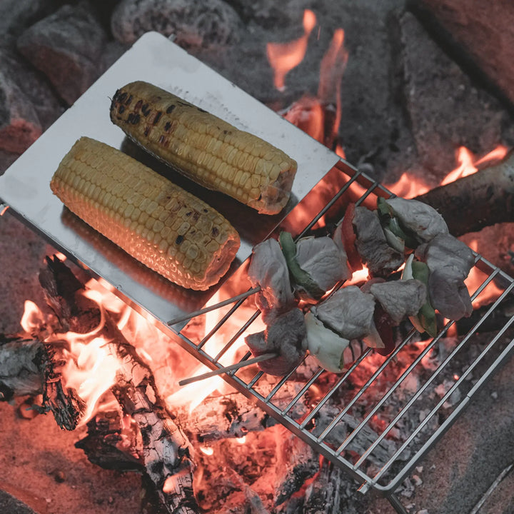 Easy Camp Campfire Grill Trivet cooking corn on the cob and meat on an open fire