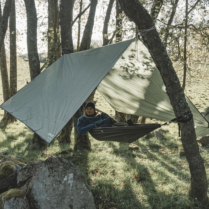 Person relaxing in a hammock under a Easy Camp Norddal Tarp 3 x 3m in a forest setting
