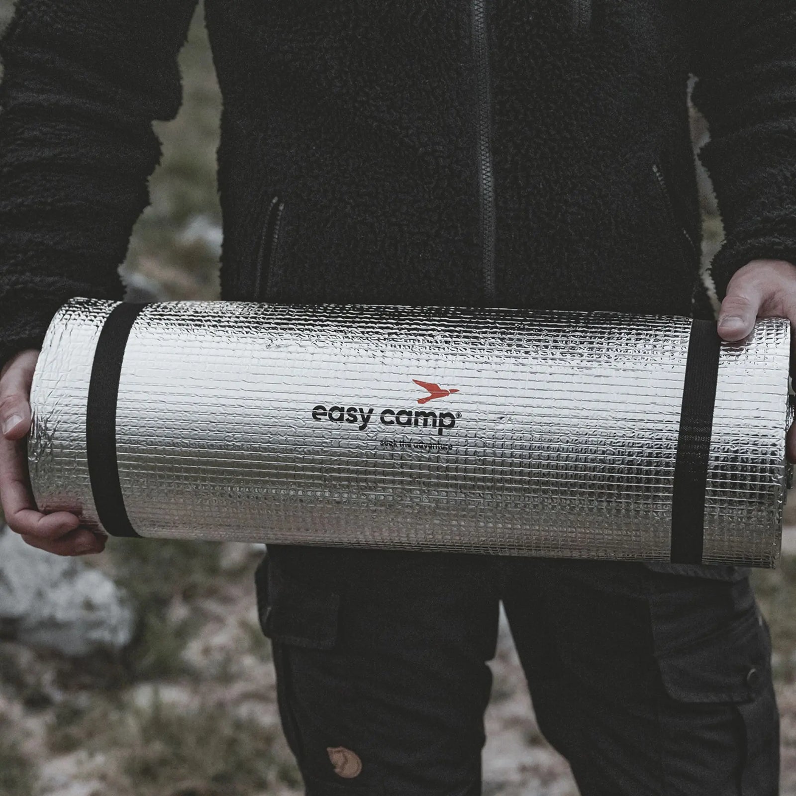 Person holding a Easy Camp Redwing Alloy EVA Mat with 'easy camp' branding in a forest setting.