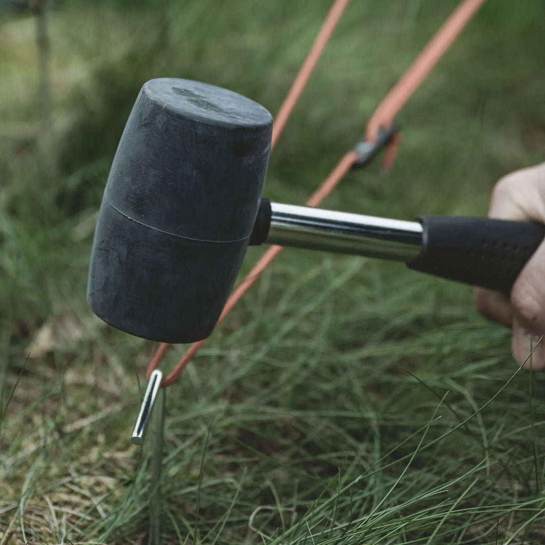 Person using a Easy Camp Rubber Mallet with a metal shaft on grass