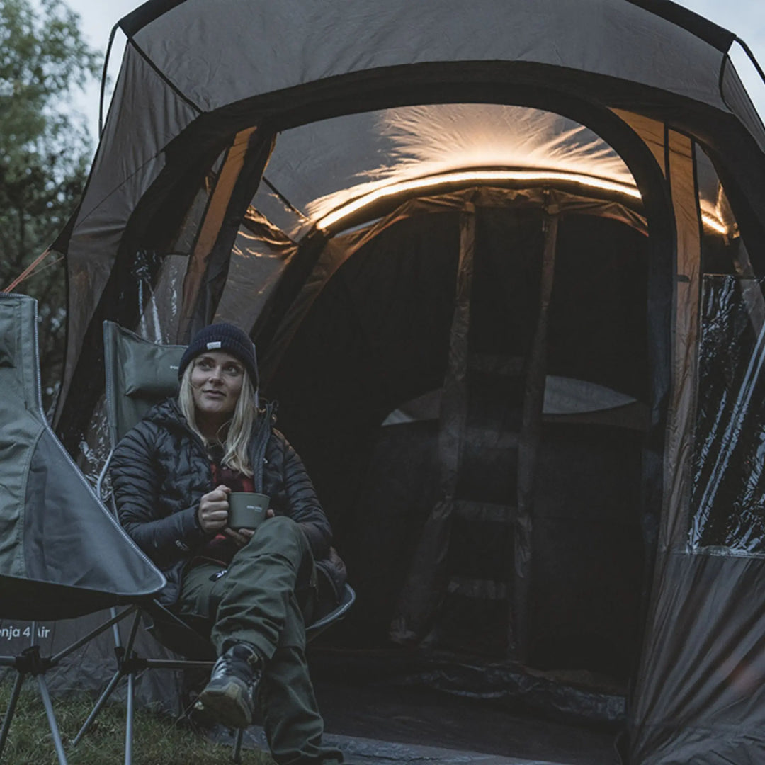 Lifestyle image of a person camping in front of the Easy Camp Senja 4 Air Tent 