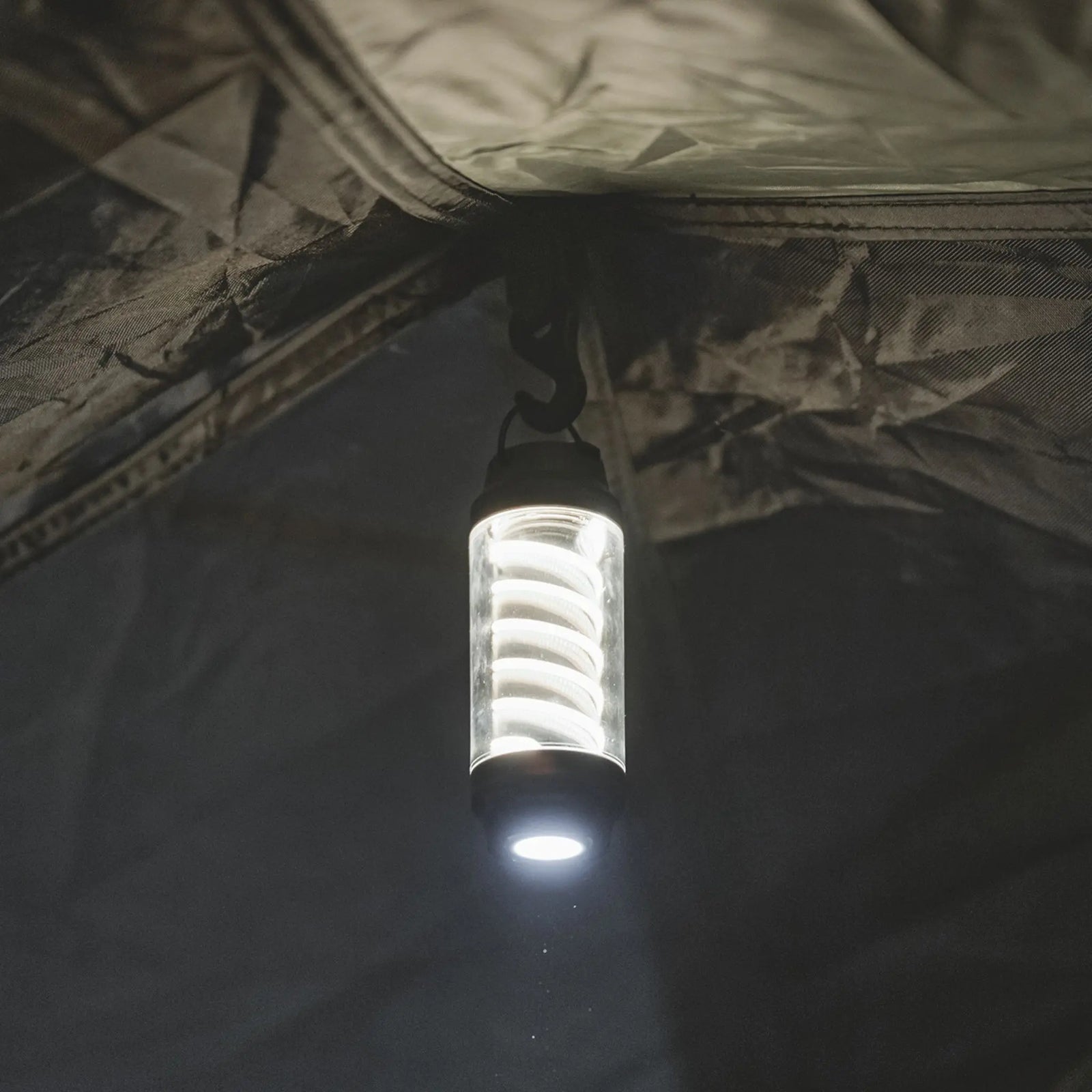 Easy Camp Wintergreen Compact Lantern hanging from a tent ceiling