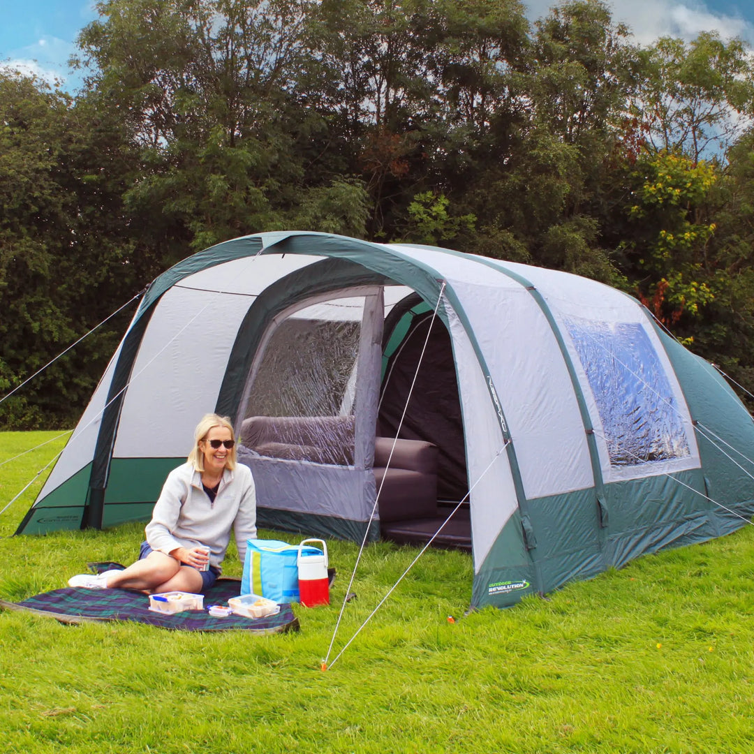 Lifestyle image of a camper sitting outside the Atom 500 Air Tent on a picnic blanket.