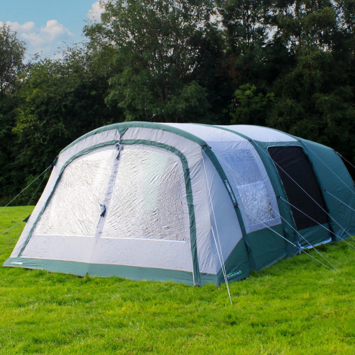 Outdoor Revolution Atom 600 Air Tent fully set up in a green campsite with trees in the background.