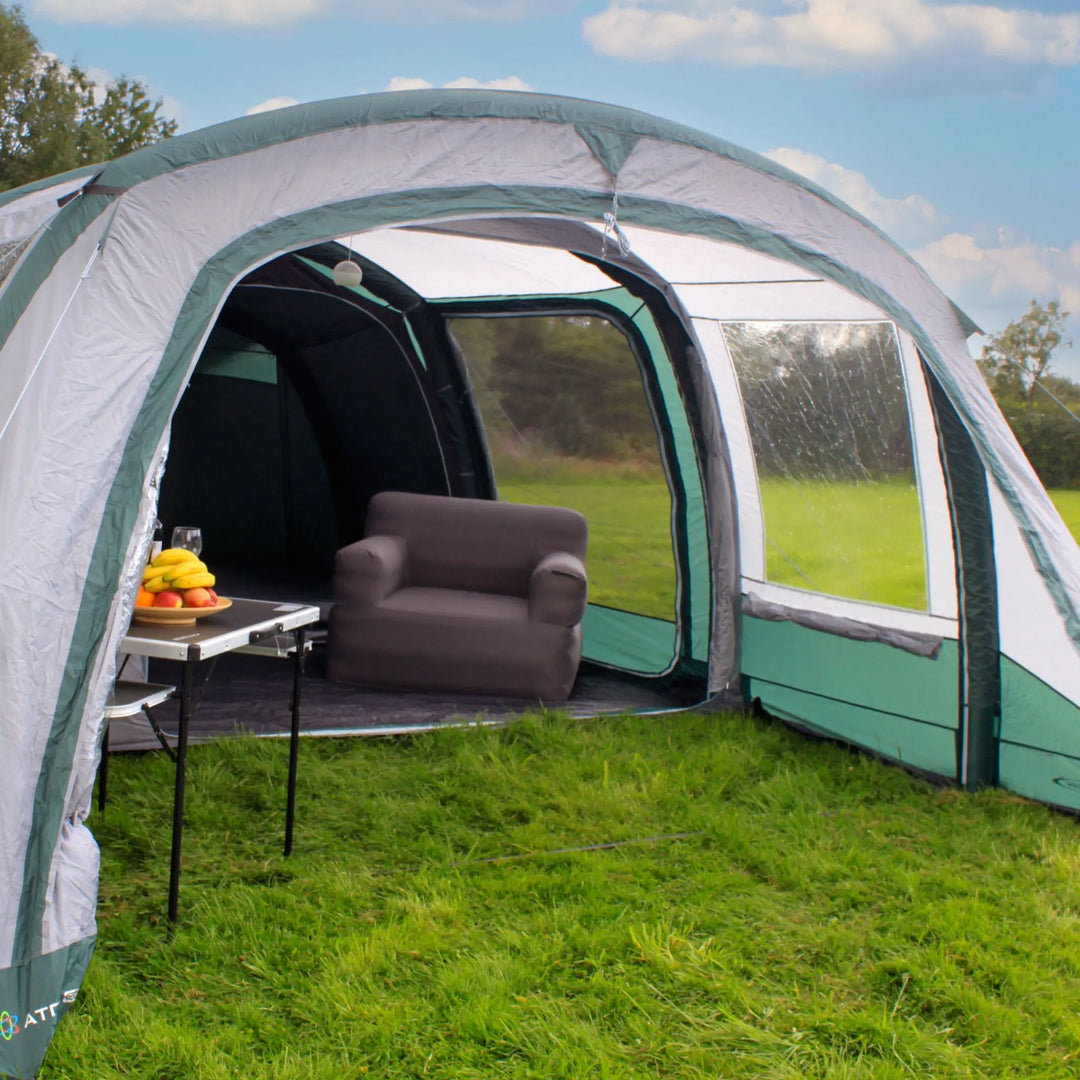 Porch section of the Outdoor Revolution Atom 600 Air Tent with a dining setup and chairs.