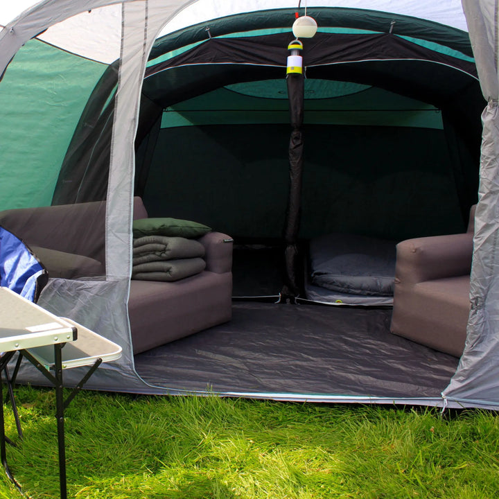 Spacious living area inside the Outdoor Revolution Atom 600 Air Tent with furniture and camping gear.