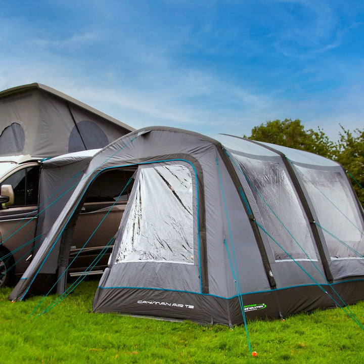 The front of the Cayman Air T3 Low campervan awning, illustrating its secure attachment to the vehicle, durable materials, and sleek inflatable structure.