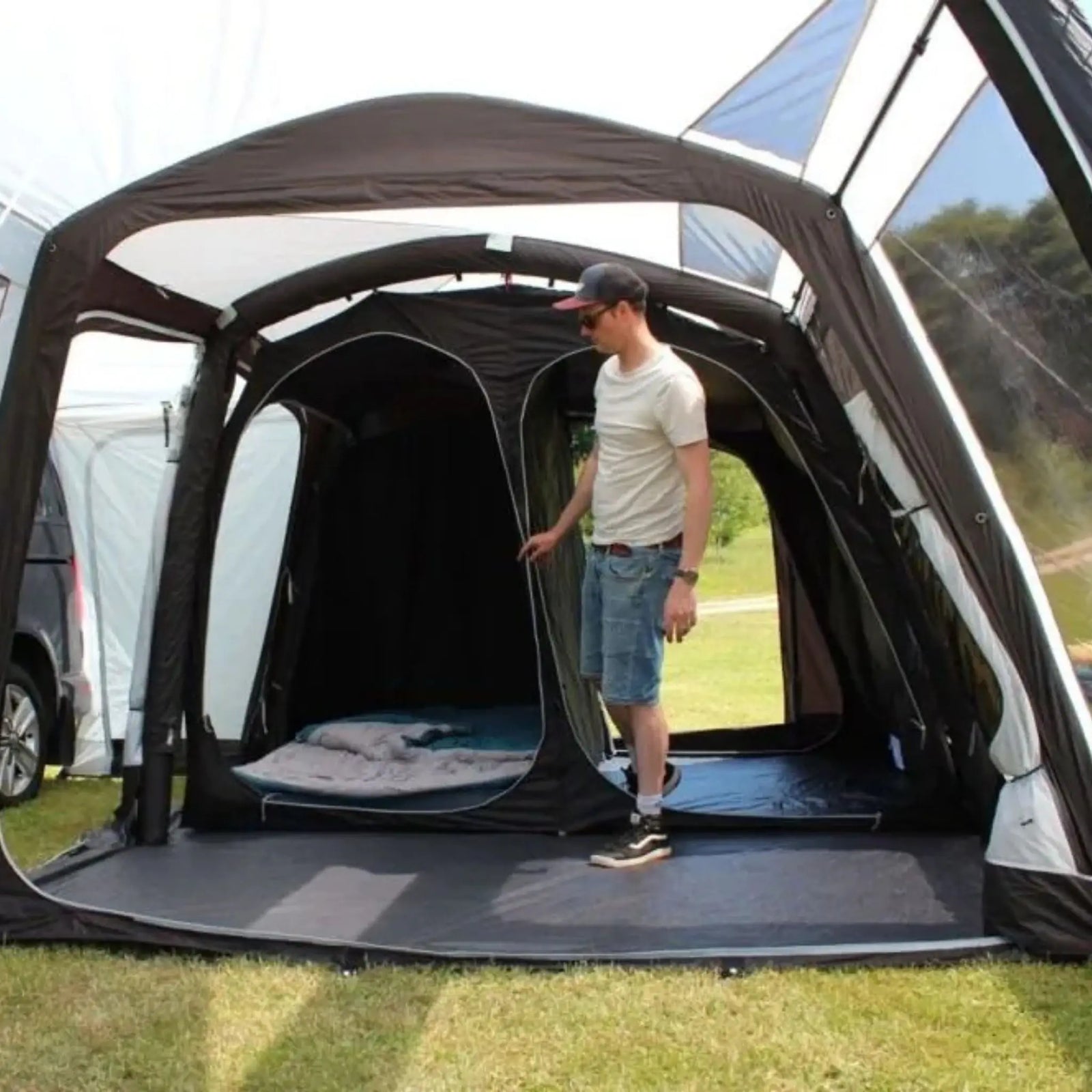 Man standing inside a Outdoor Revolution Movelite 4 Berth Inner Tent on grass with trees in the background