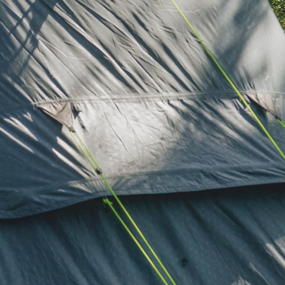 Close-up of the ventilation panel on a  Outwell Earth 3 Plus Tent with green ropes on a grey background