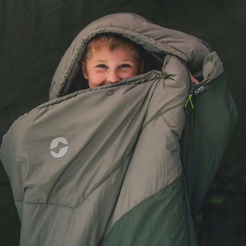 Child peeking out from an Outwell sleeping bag inside a tent.