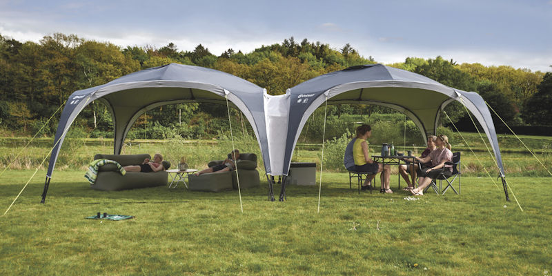 Outwell Summer Lounge XL in a field with people sitting underneath