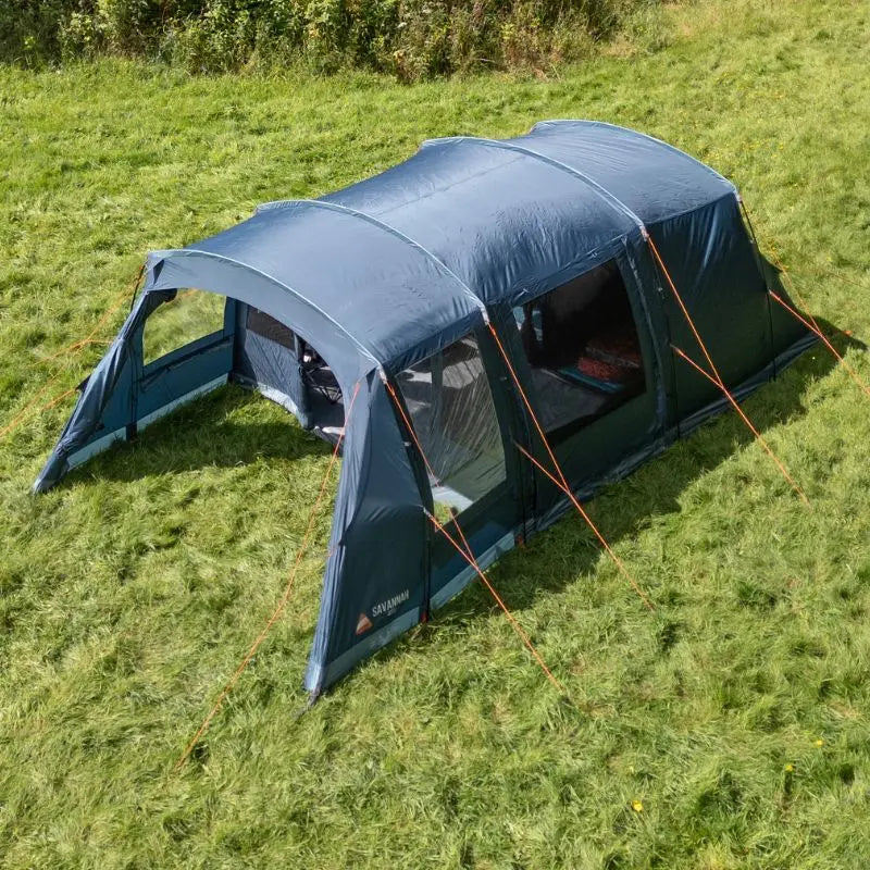 Blue Vango 4 person tent with afornt awning on a grassy field