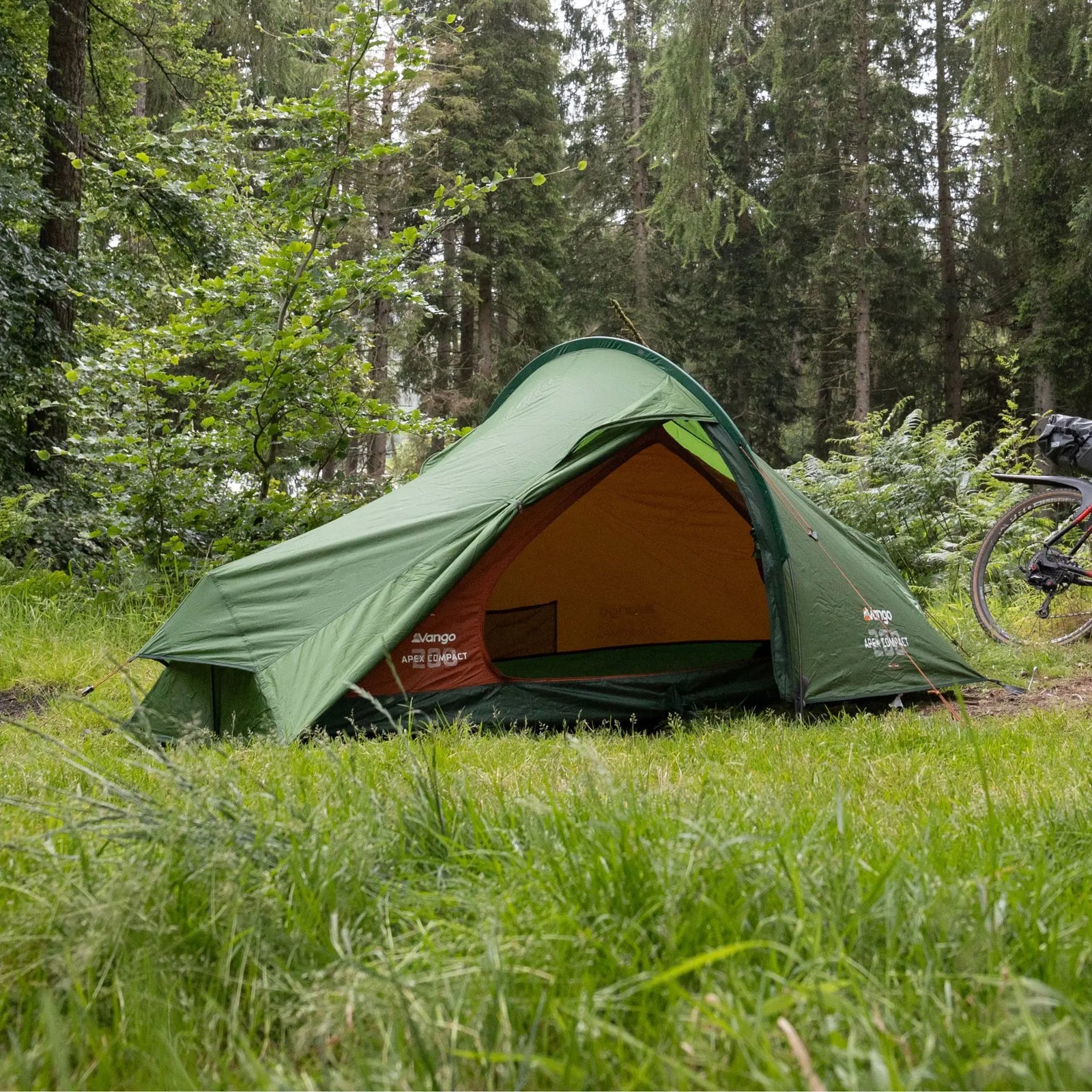 The Vango Apex Compact 200 Tent pitched in a forest setting, showcasing its suitability for trekking and hiking.