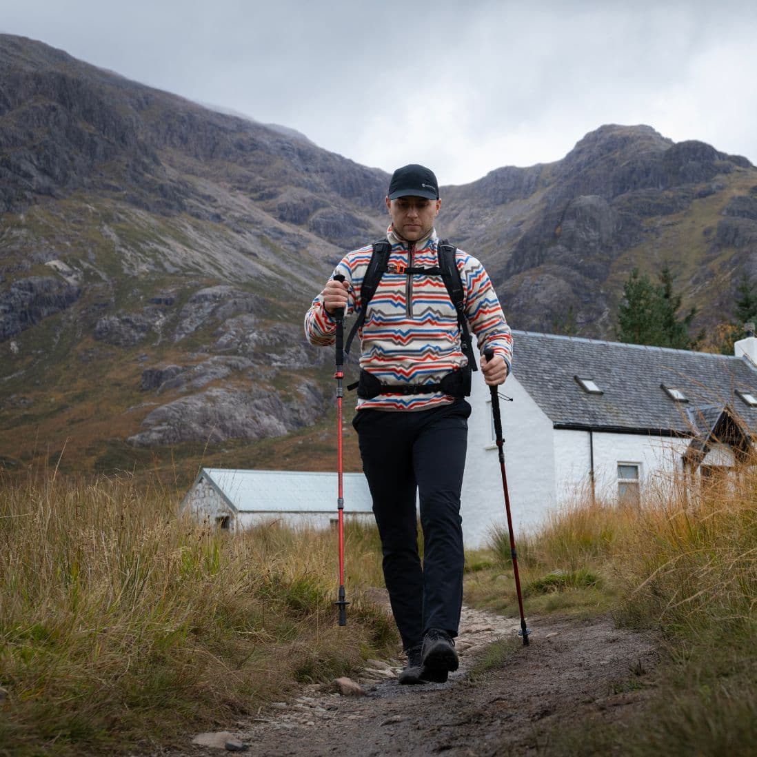 Front view of a hiker using Vango Basho Walking Poles against a scenic mountain backdrop, perfect for hiking and trekking.