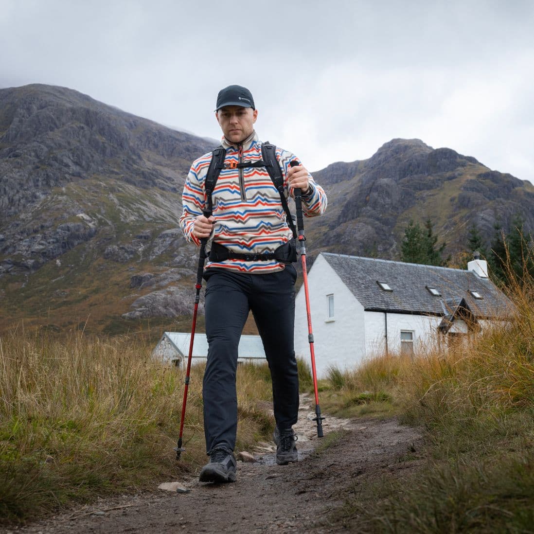 Front view of a hiker using Vango Basho Walking Poles against a mountain backdrop.