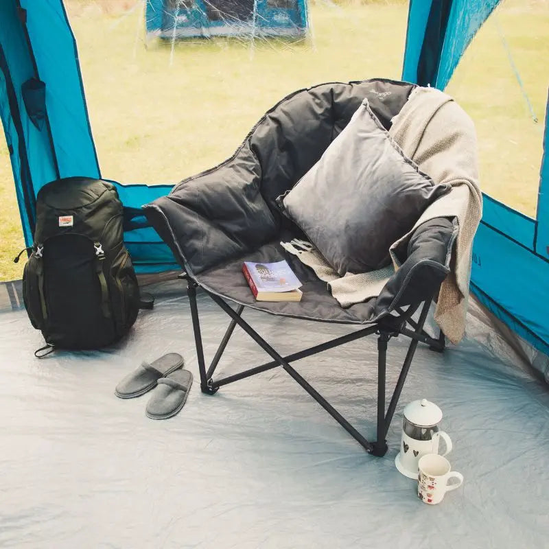 Vango Camping chair with blanket, books, and backpack inside a tent.
