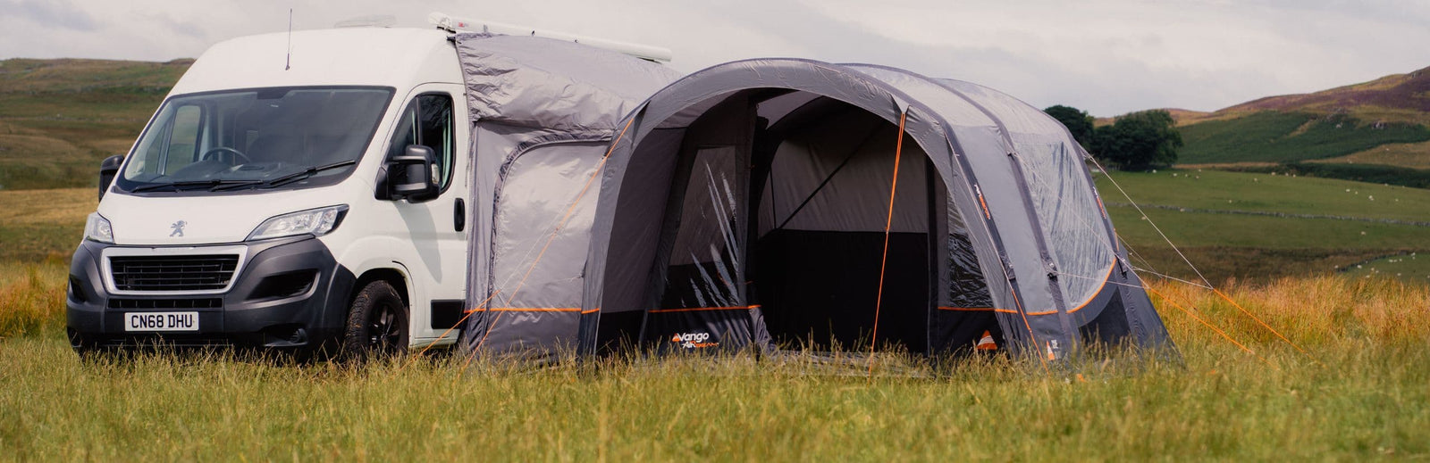 The Vango Cove III Air Mid Awning pitched in a campsite, demonstrating its spacious living area and compatibility with various motorhomes.