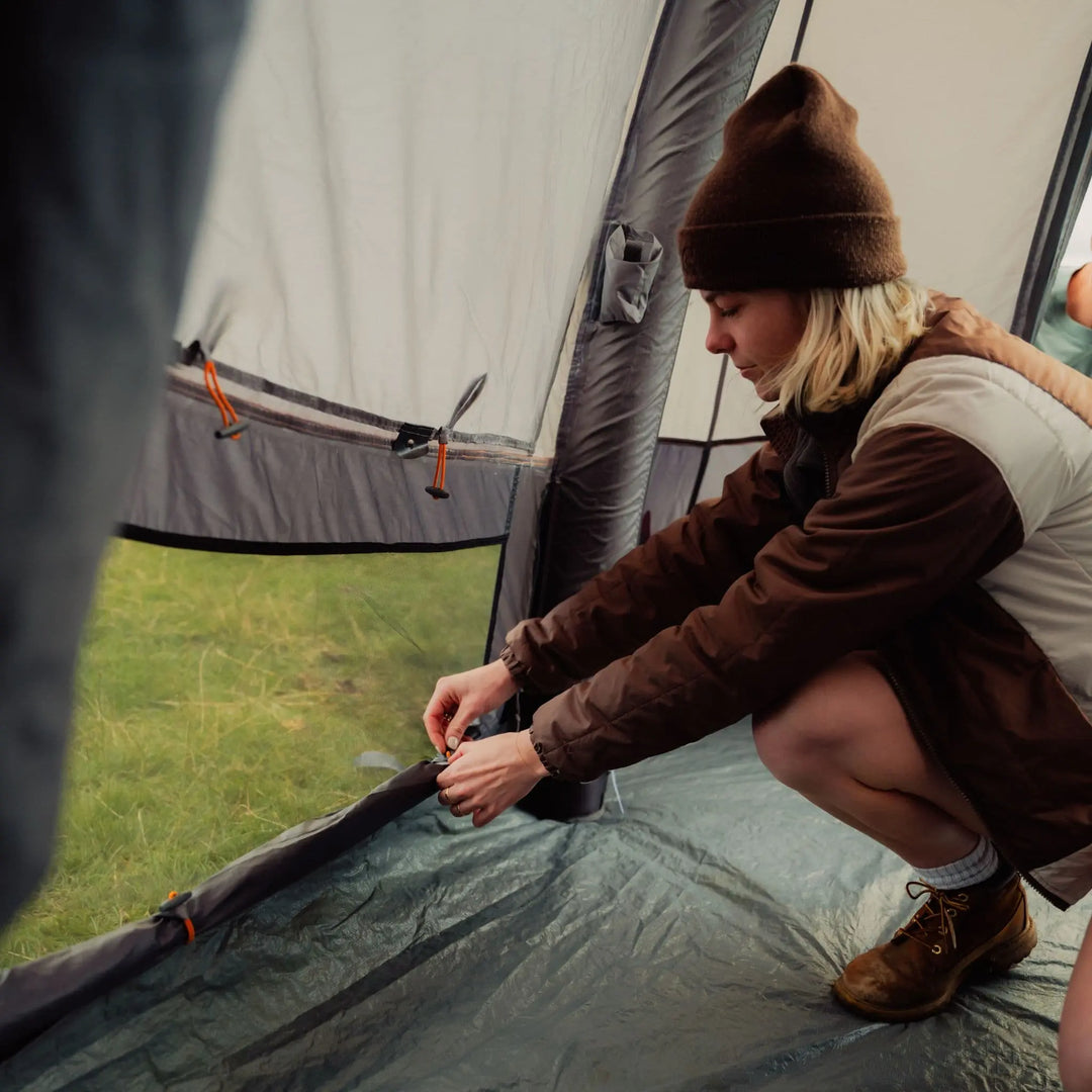 Person adjusting a ventilation panel the Vango Cove III Air Low awning, demonstrating its ease of use and ability to enhance airflow within the awning for a comfortable camping experience. .