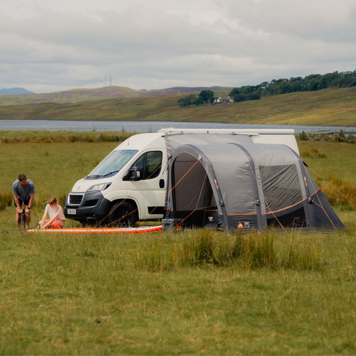 The Vango Cove III Air Mid Drive Away Awning connected to a van, with its large windows providing bright and airy views.