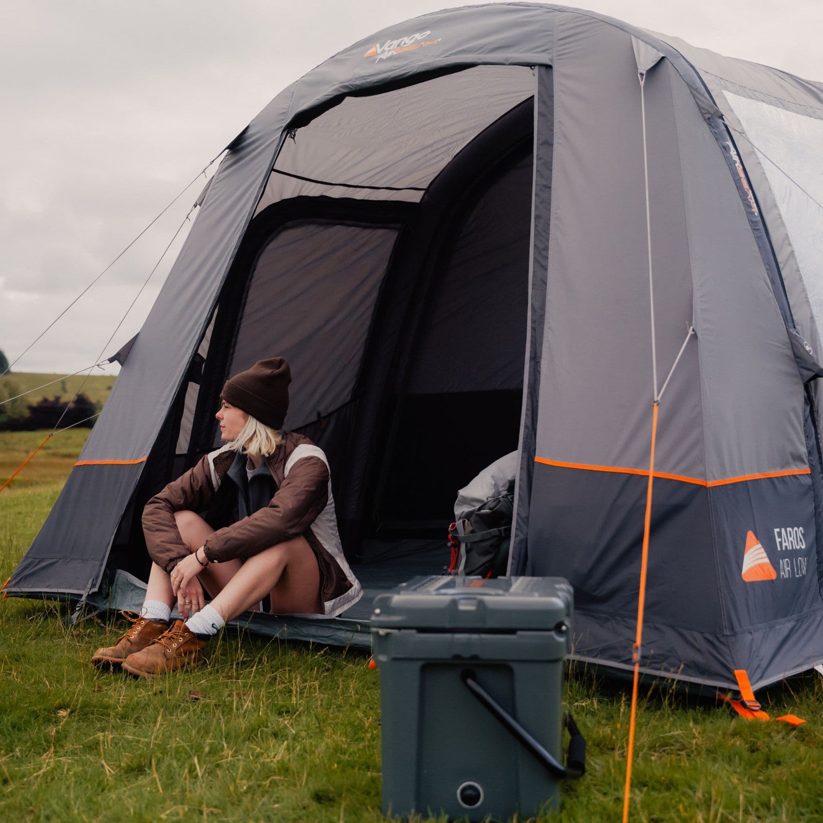 Side view of the Vango Faros III Air Low VW Campervan Awning with a camper sitting outside, highlighting the extra space for relaxation and gear storage.