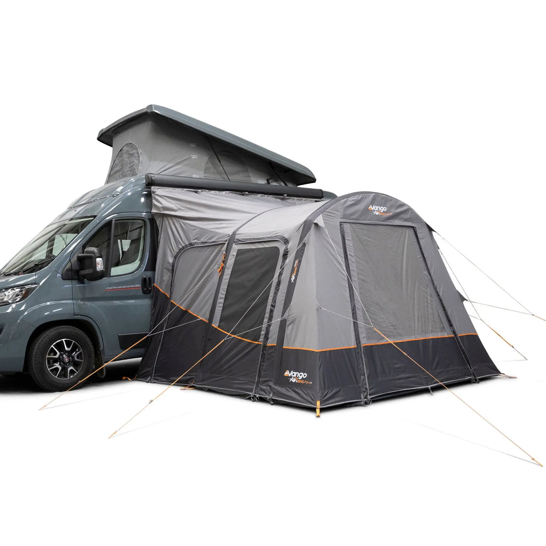 A Vango Faros III Air Mid Drive Away Awning with orange accents, shown attached to the side of a blue-gray van with its roof raised, on a plain white background.
