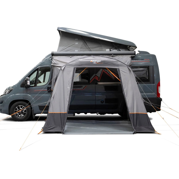 A Vango Faros III Air Mid Drive Away Awning with orange accents, shown attached to the side of a dark grey van on a clean white background.