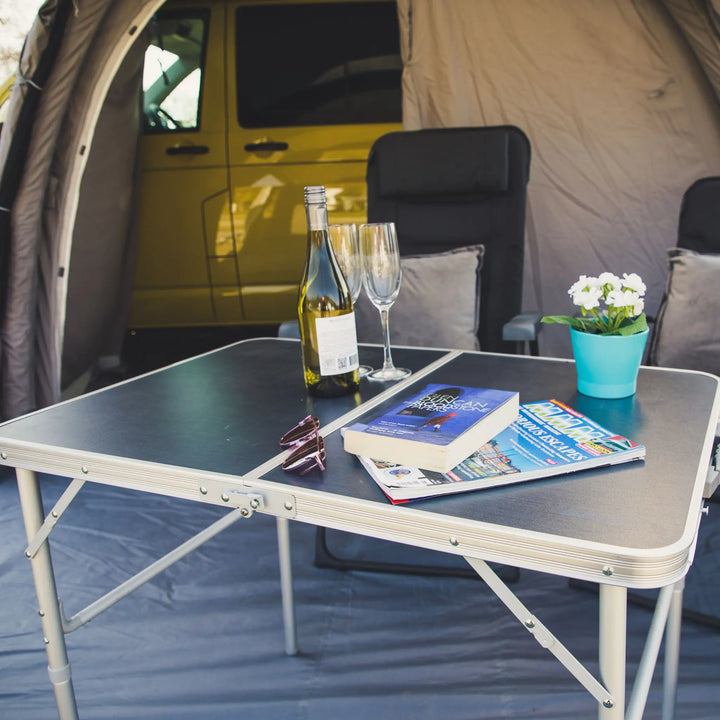 Vango Granite Duo 90 table, books, wine, and glasses inside an awning.