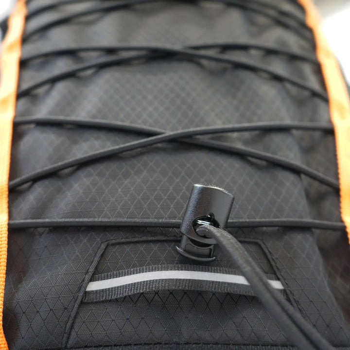 Close-up of the bungee cord detailing on the front of the Vango Hex Rolltop 25L backpack, designed for quick-access storage.