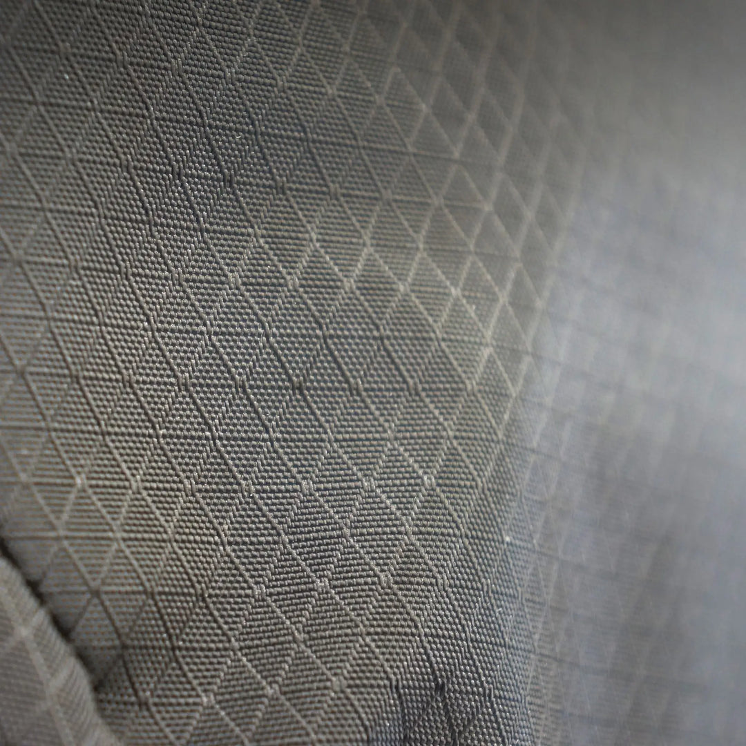 Fabric texture close-up of the Vango Hex Rolltop 25L rucksack, showcasing durable diamond ripstop material for outdoor durability.