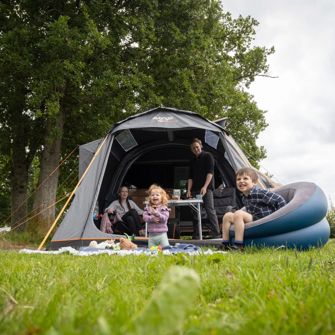 Family camping outdoors with a Vango Kela Edition 60 Drive Away Awning and inflatable chair.