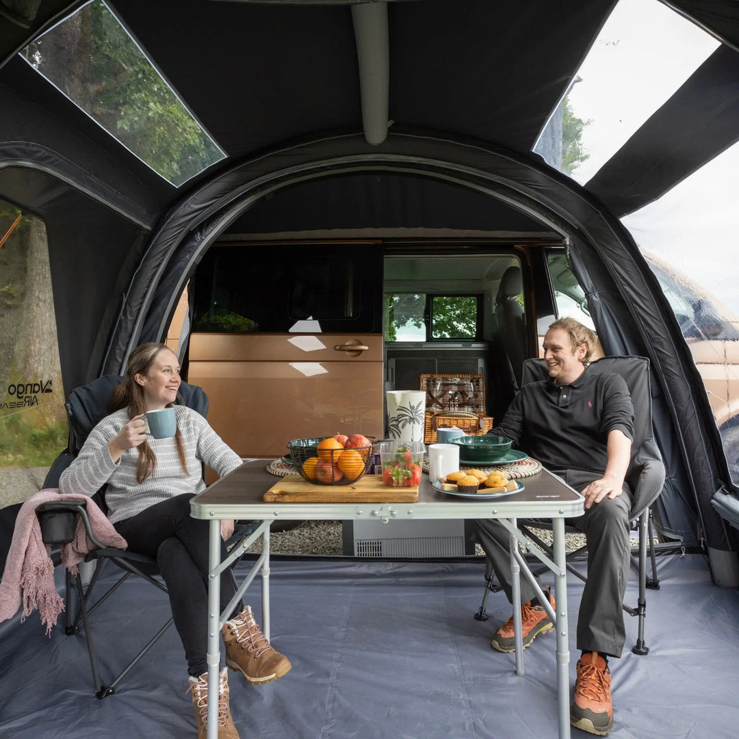 Two people sitting in the living area of of the Vango Kela Edition 60 Drive Away Awning.
