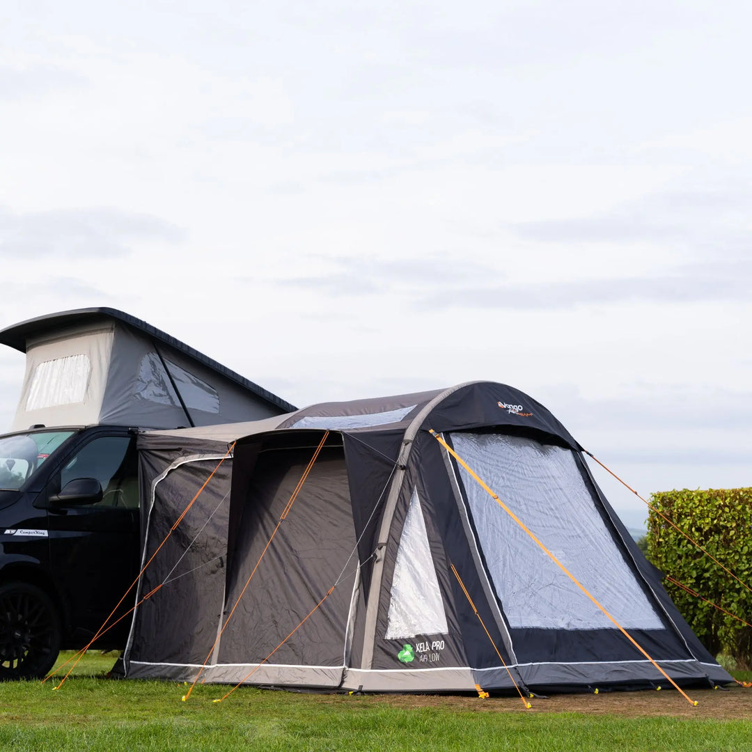 Vango Kela Pro Air Low drive-away awning attached to a campervan with a pop-up roof, secured with bright orange guy ropes.